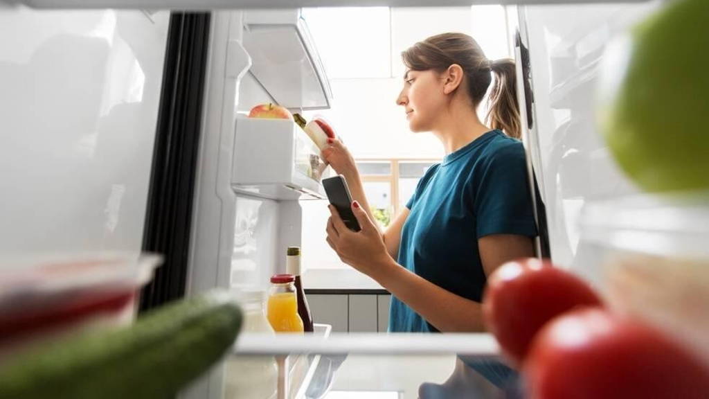 Vrouw-smartphone-koelkast-eten-leefstijl