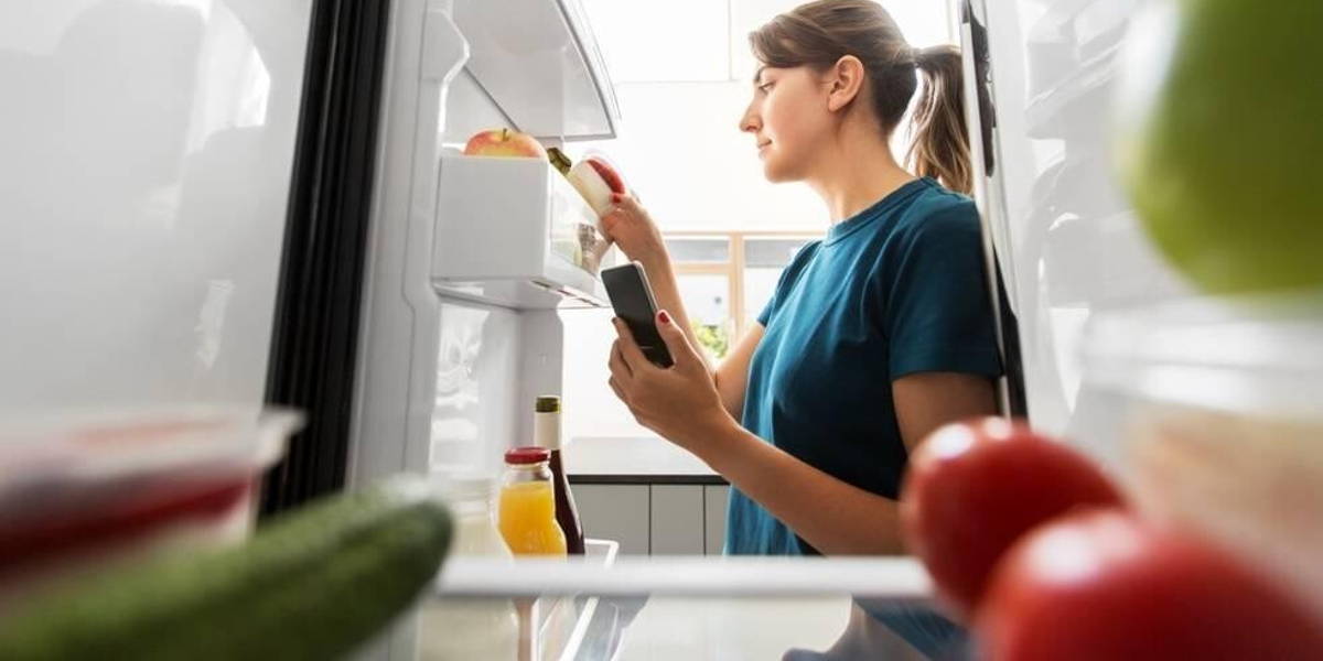 Vrouw-smartphone-koelkast-eten-leefstijl