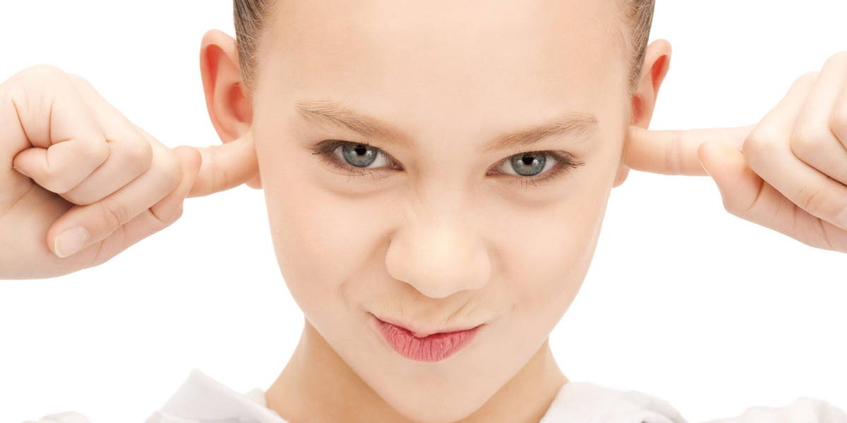 teenage girl with fingers in ears
