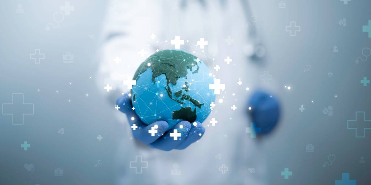 Close-up van een persoon in een witte doktersjas en blauwe handschoenen die een verlichte, blauwe wereldbol vasthoudt.