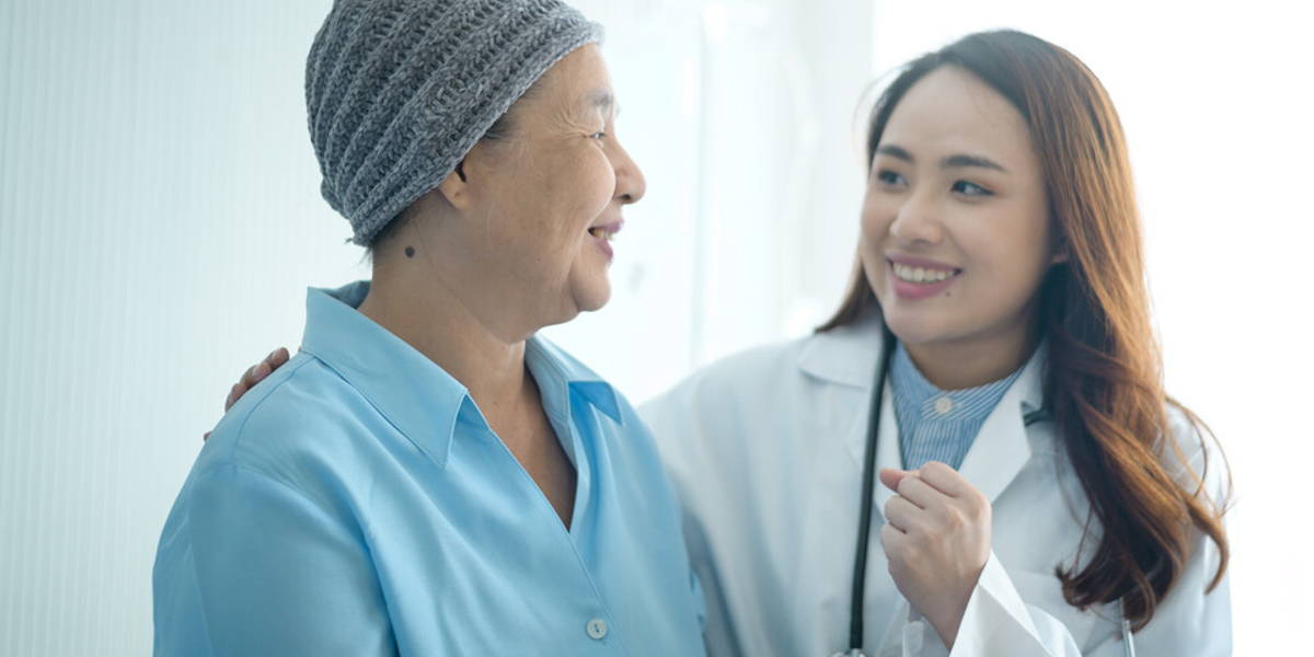 Cancer patient woman wearing head scarf after chemotherapy consulting and visiting doctor in hospital.