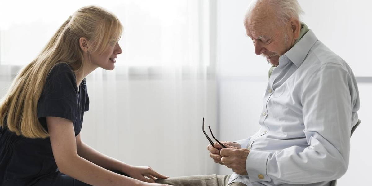 nurse having conversation with old man nursing home