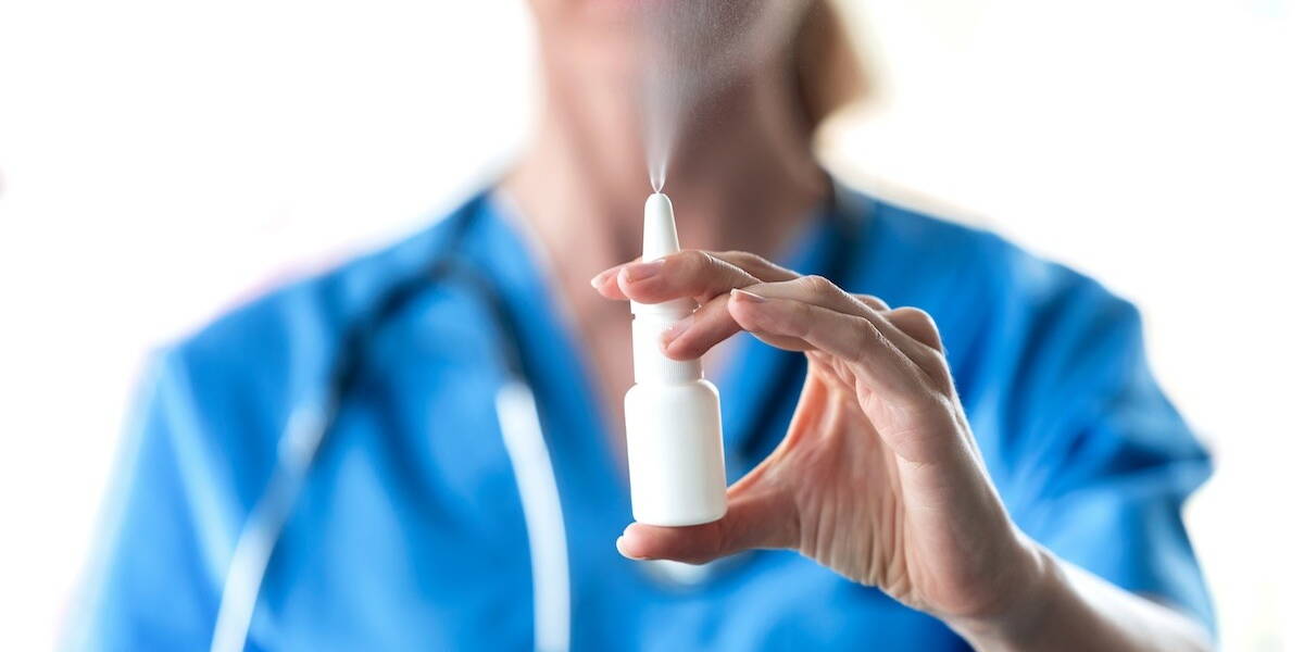 Dokter met flesje neusspray