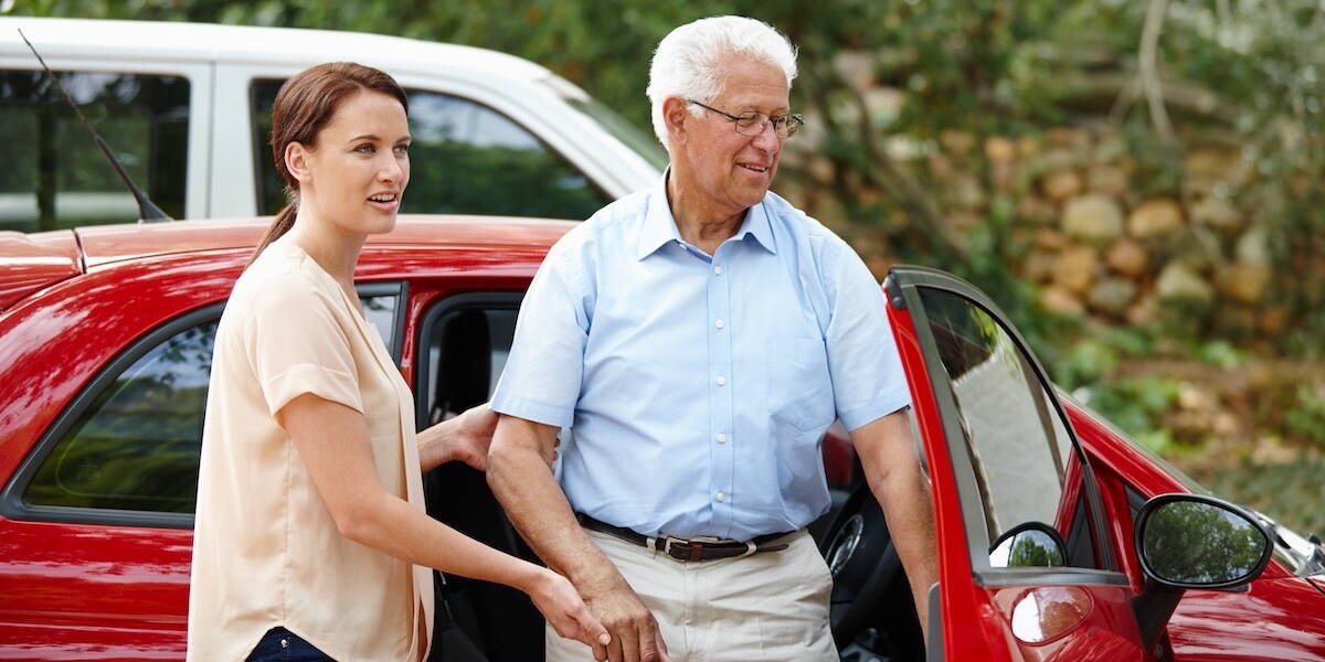 Vrouw helpt patiënt uit de auto