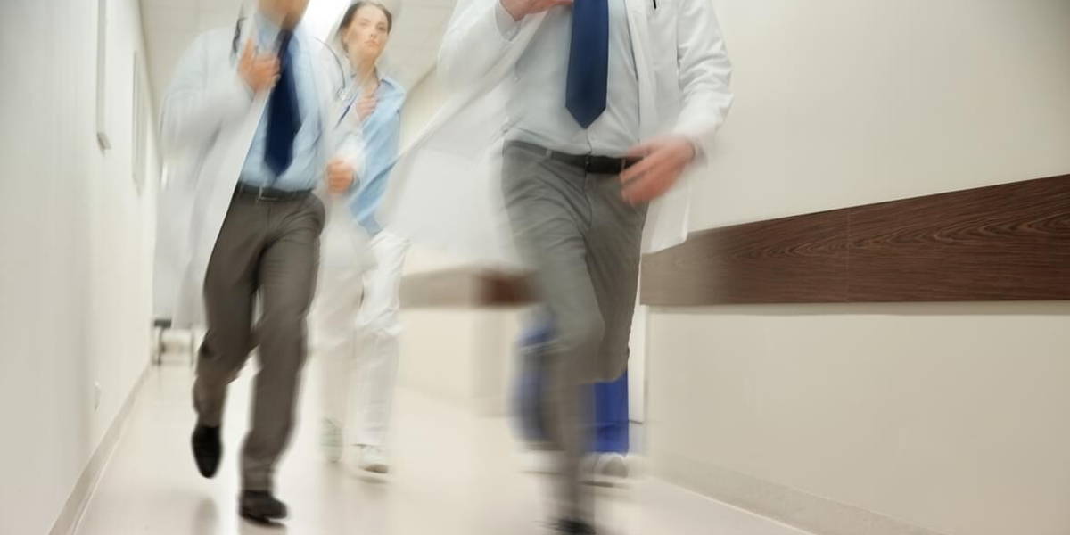 close up of medics or doctors running at hospital