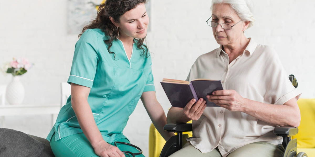 disabled senior female patient sitting wheel chair reading book with nurse