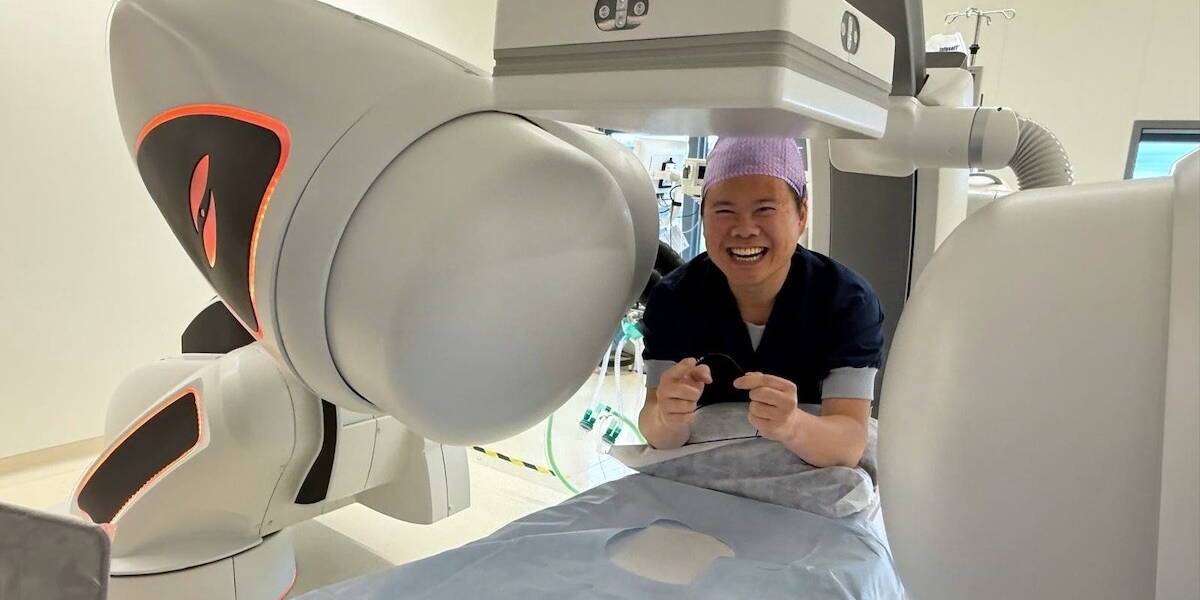 Lachende ziekenhuismedewerker staat bij een bed in een operatiekamer