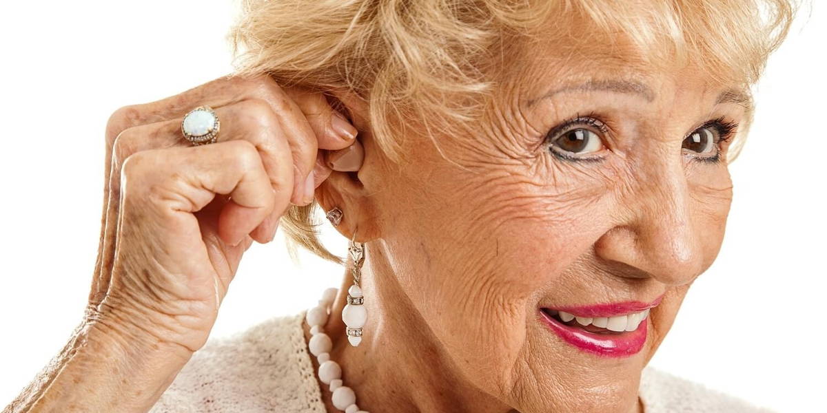 Senior Woman Inserts Hearing Aid