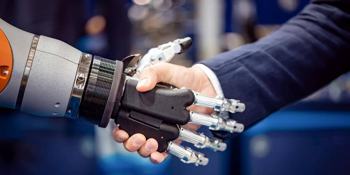 Hand of a businessman shaking hands with a Android robot.