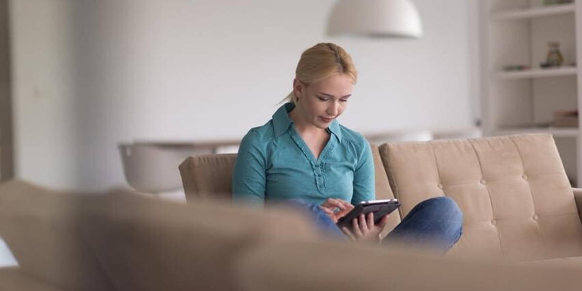 woman on sofa using tablet computer