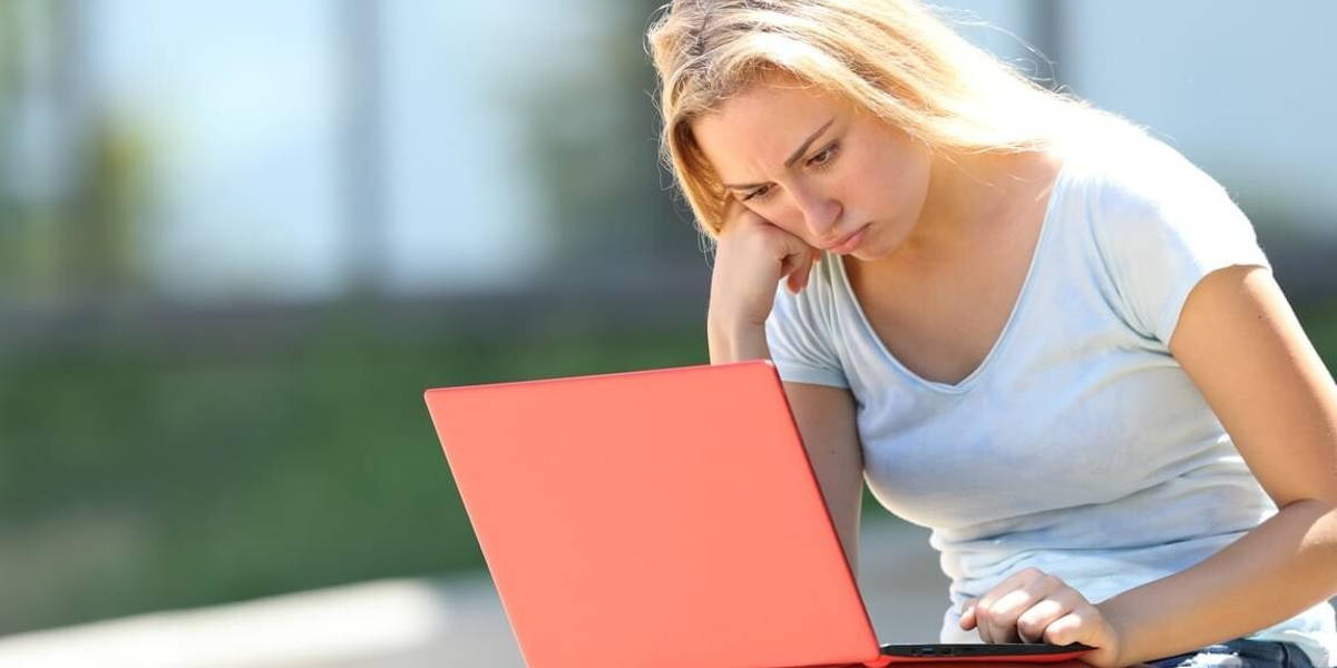 Frustrated student studying using laptop in a campus