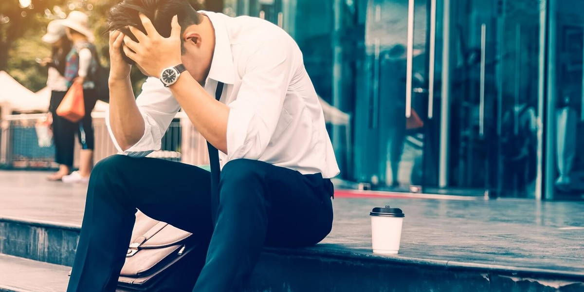 Workers man sitting headache in front of the company about his w