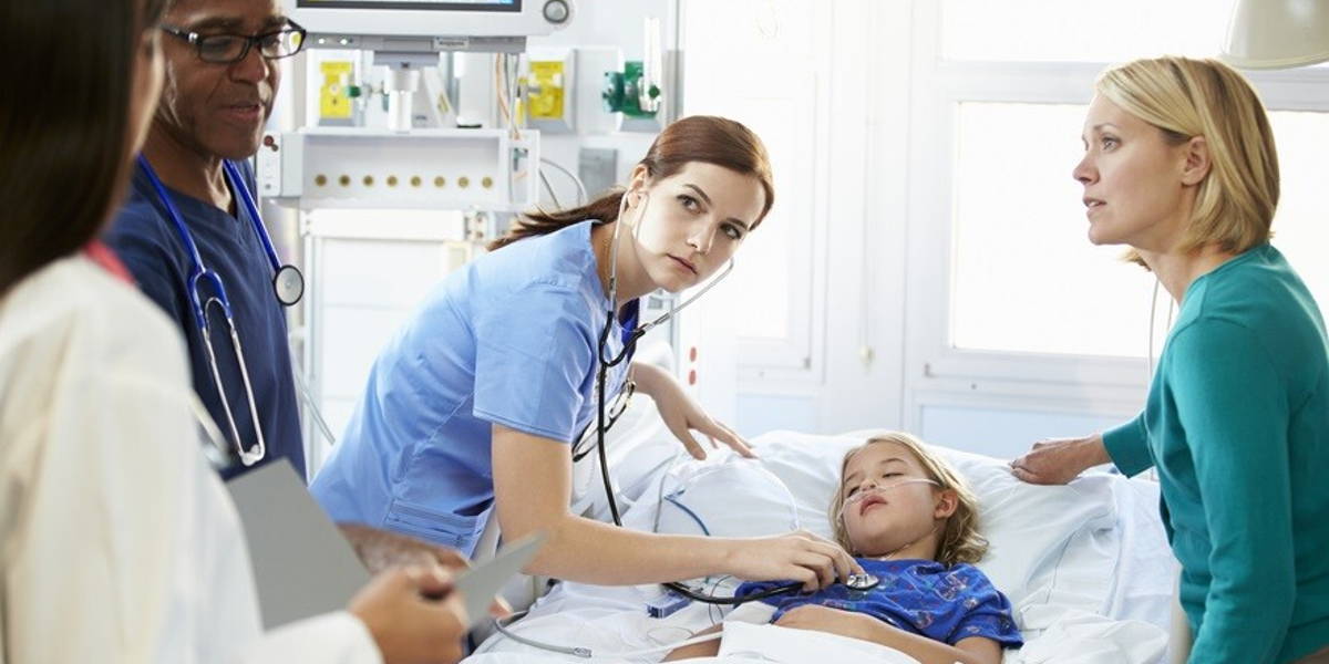 Mother And Daughter With Staff In Intensive Care Unit