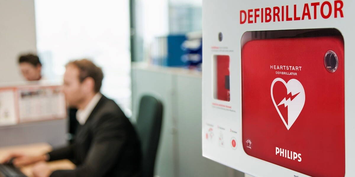 Rode defibrillator van Philips in een kantooromgeving