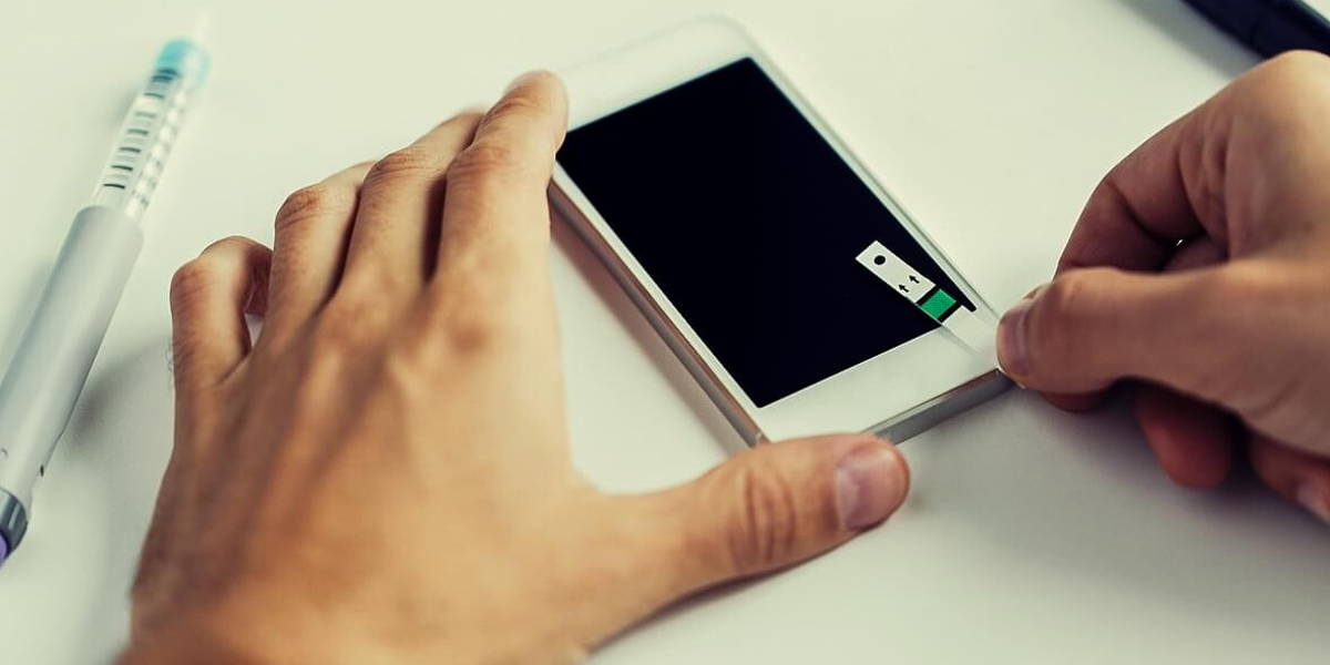 close up of man with smartphone making blood test