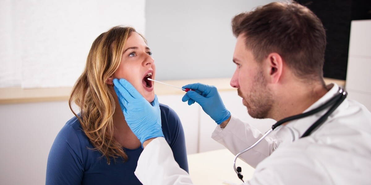 Arts voert speekseltest uit bij vrouw