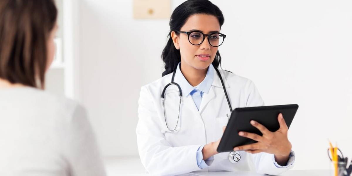 doctor with tablet pc and woman at hospital